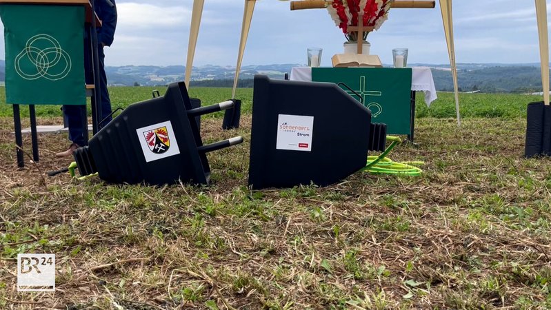 Auf einem Feld liegt ein überdimensional großer Elektrostecker. | Bild: BR Auf einem Feld liegt ein überdimensional großer Elektrostecker.