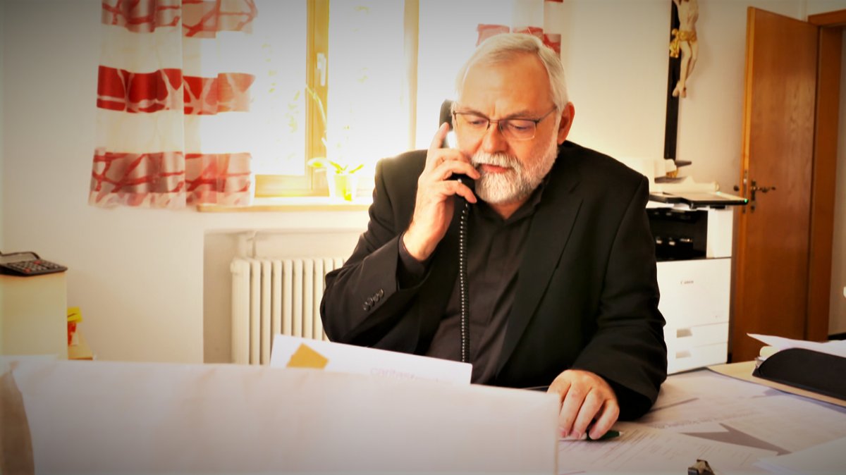 Pfarrer Martin Neidl telefoniert im Pfarrbüro. 