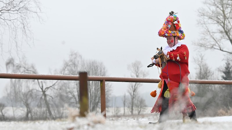 Ein verkleideter Mann reitet auf einem Steckenpferd (Symbolbild) | Bild: picture alliance / CTK | Lubos Pavlicek Ein verkleideter Mann reitet auf einem Steckenpferd (Symbolbild)