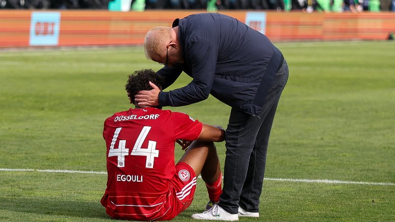 Fürths Trainer Vogel tröstet Düsseldorfer Spieler | Bild: picture-alliance/dpa Fürths Trainer Vogel tröstet Düsseldorfer Spieler