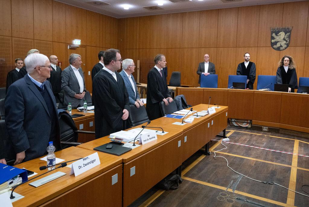 04.03.2024, Hessen, Frankfurt/Main: Die Angeklagten Theo Zwanziger (l), ehemaliger Präsident des Deutschen Fußball-Bundes (DFB), Wolfgang Niersbach (2.v.l., hinten), ehemaliger DFB-Präsident, und Horst R. Schmidt (r), ehemaliger DFB-Generalsekretär, erheben sich zum Auftakt des «Sommermärchen-Prozesses» im Verhandlungssaal am Landgericht. In dem Prozess müssen sich die drei ehemaligen Top-Funktionäre des Deutschen Fußball-Bundes (DFB) wegen des Verdachts der Steuerhinterziehung in einem besonders schweren Fall verantworten. Foto: Boris Roessler/dpa +++ dpa-Bildfunk +++