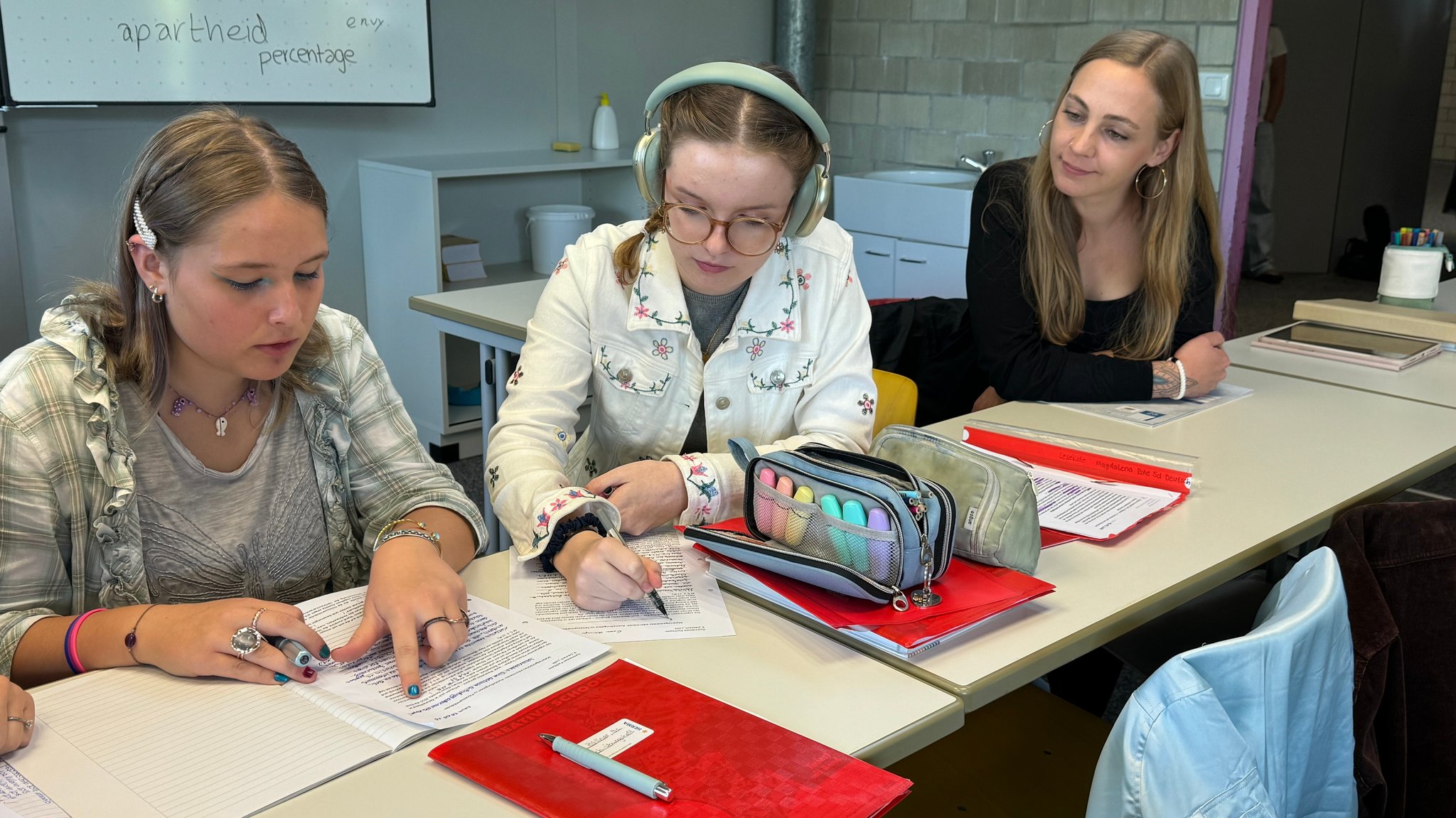Die 14-jährige Emma arbeitet in einem Klassenraum an einem Arbeitsblatt, neben ihr sitzt ihre Schulbegleiterin. | Bild: Katrin Bohlmann/BR Die 14-jährige Emma arbeitet in einem Klassenraum an einem Arbeitsblatt, neben ihr sitzt ihre Schulbegleiterin.