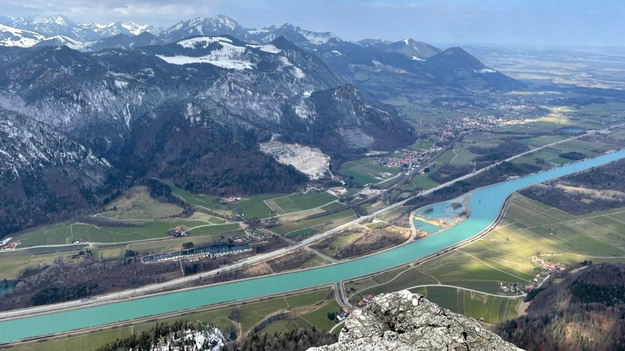 Berglandschaft mit einem breiten Tal, durch die ein Fluss fließt