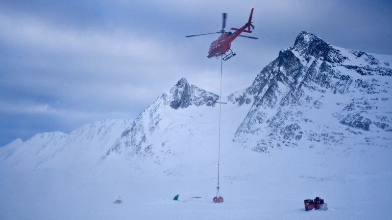 Helikopter fliegt über dem Gletscher an der Küste Südost-Grönlands.