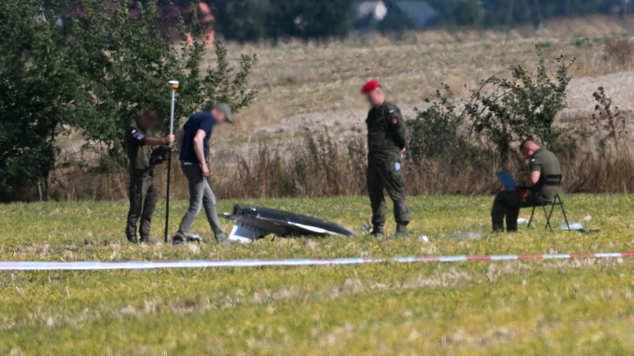10.09.2025, Polen, Wohyn: Polizei und Militärpolizei sichern Teile einer beschädigten Drohne, die von polnischen Behörden abgeschossen wurde, auf einem Gelände in Wohyn.