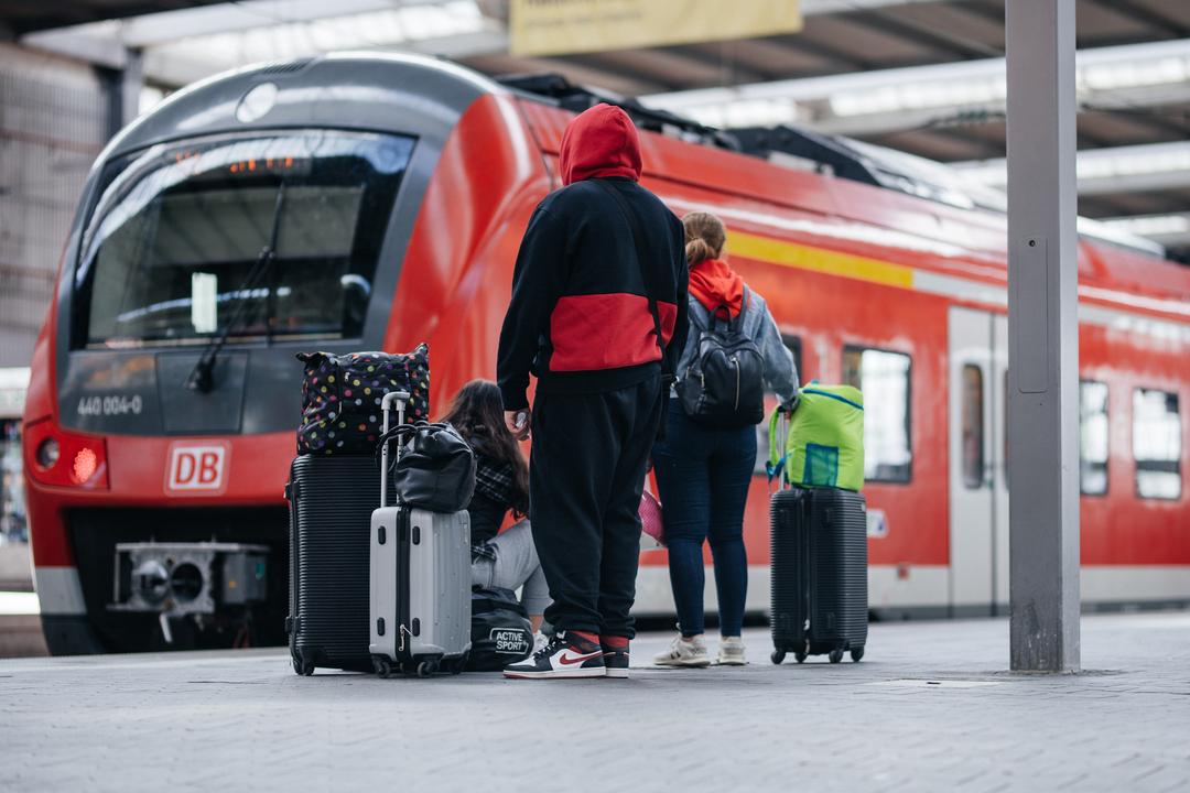 Symbolbild: Menschen warten am Gleis auf einen Zug. 