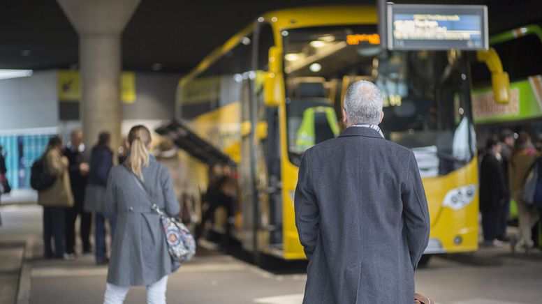 Menschen stehen wartend vor einem gelben Reisebus. | Bild:BR/Max Hofstetter