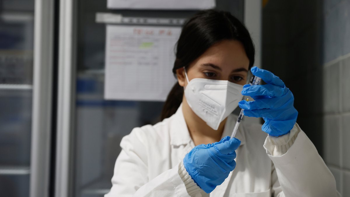 Eine Frau im Laborkittel, mit Maske und blauen Einmalhandschuhen zieht eine Spitze auf. Der Freistaat fördert 14 multidisziplinäre Projekte zur Forschung am Post-Covid-Syndrom mit zehn Millionen Euro. (Symbolbild) 