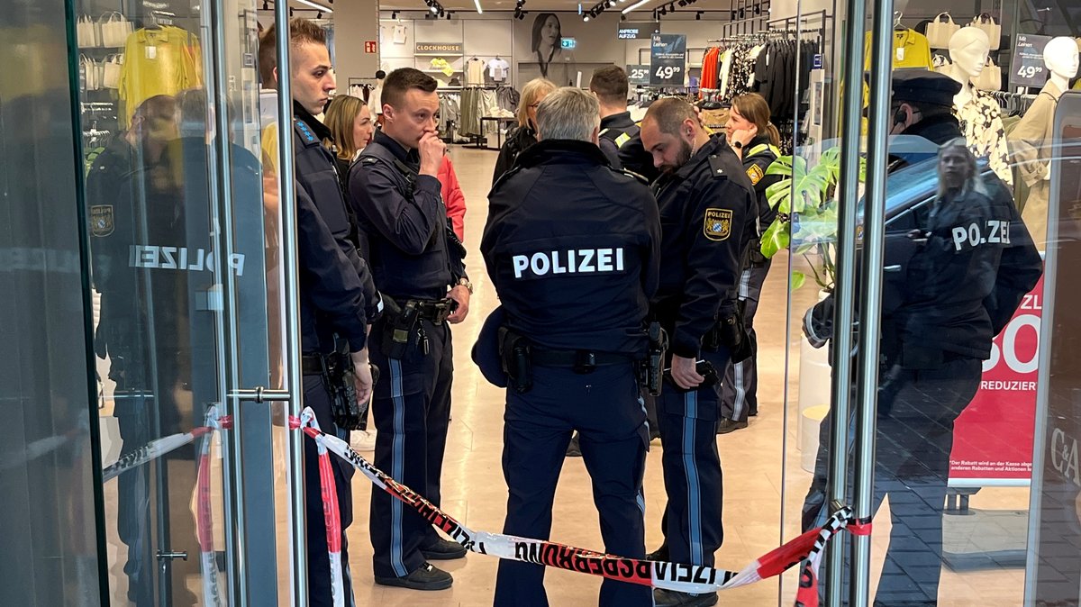 Mehrere Polizisten stehen nach den Bränden in einem Kaufhaus