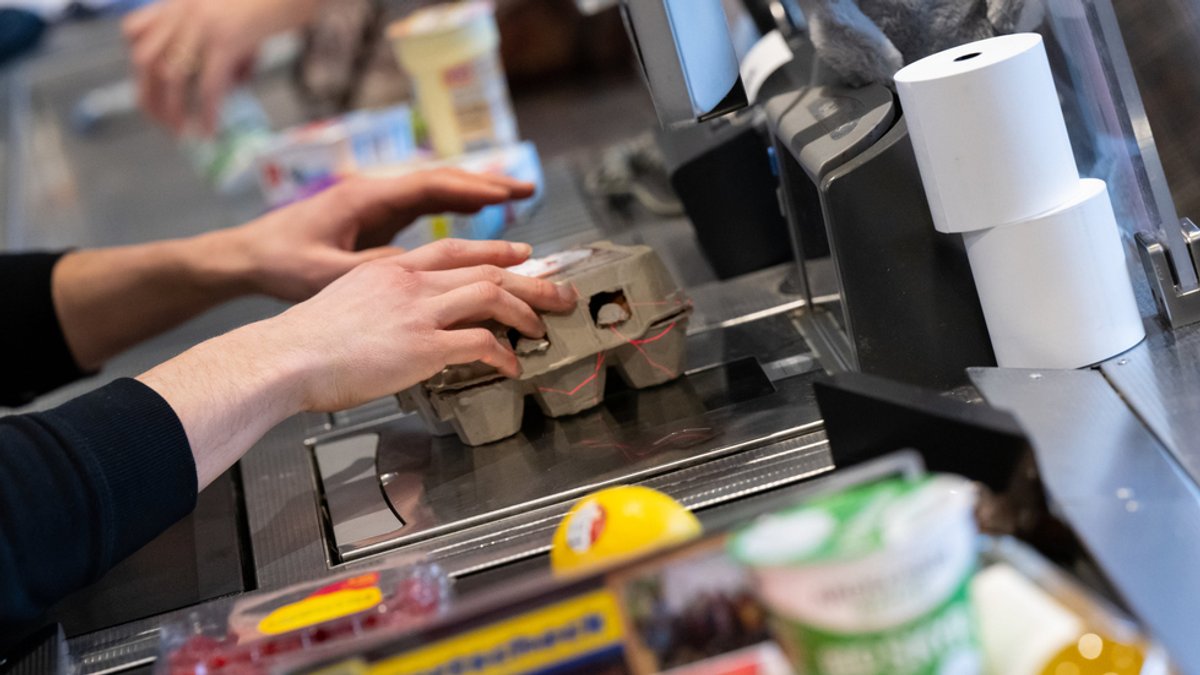 Ein Kassierer scannt in einem Supermarkt an der Kasse die Produkte. (Symbolbild)