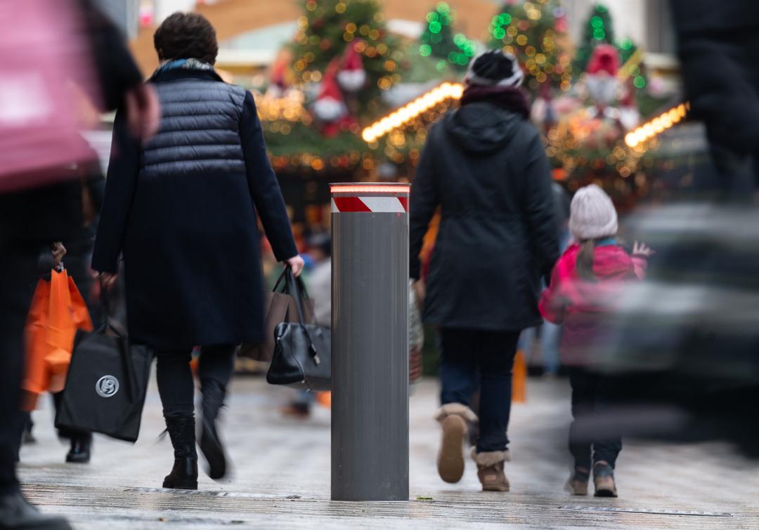 Eine festverbaute Polleranlage ist an einer Straße am Rand eines Weihnachtsmarktes zu sehen. 