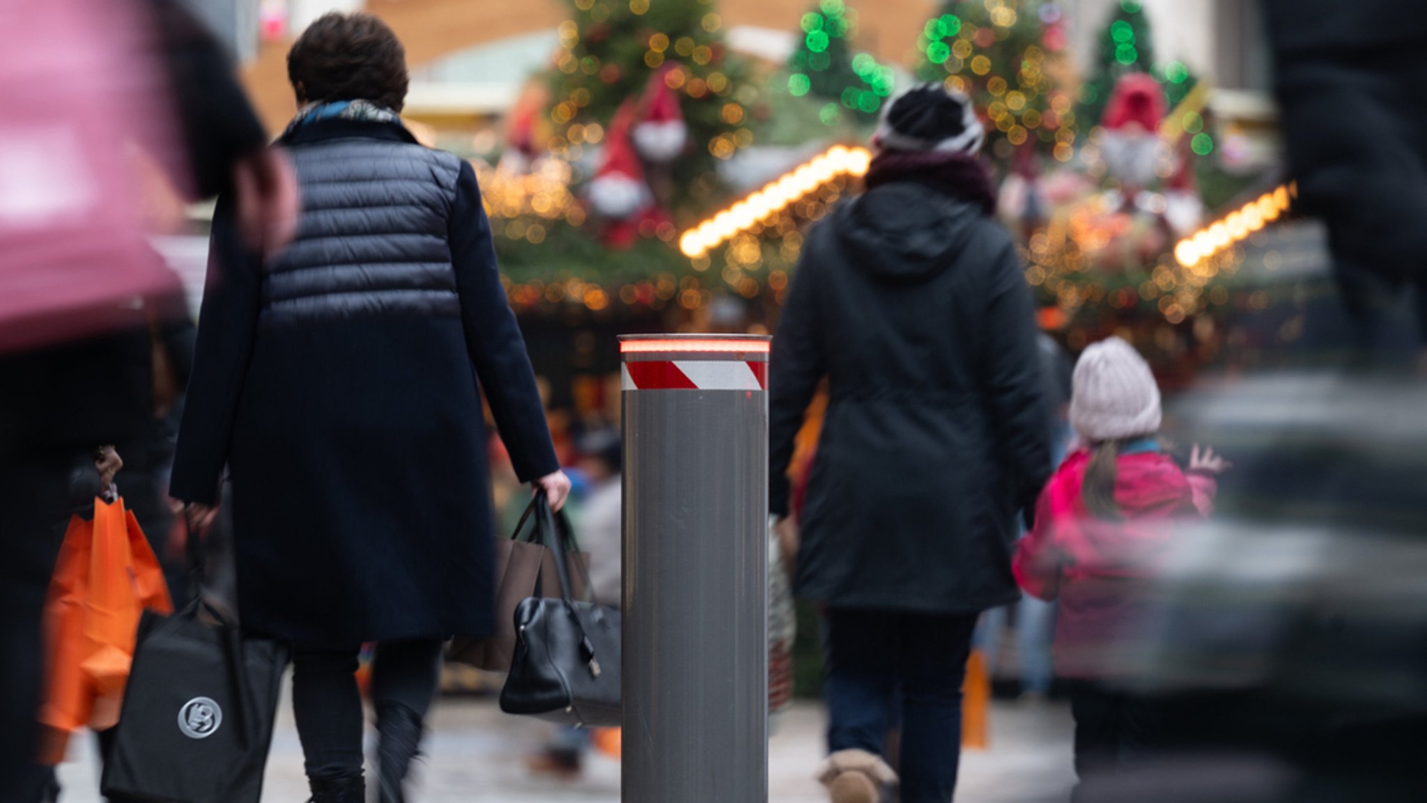 Eine festverbaute Polleranlage ist an einer Straße am Rand eines Weihnachtsmarktes zu sehen. 