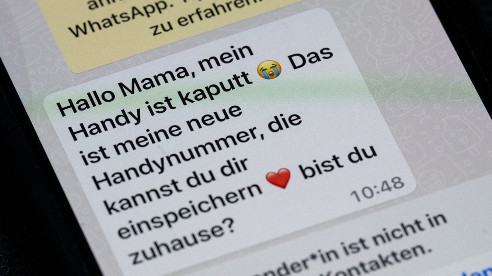 uf dem Display eines Smartphones steht eine Whats App-Nachricht, die im Tonfall betrügerischen Nachrichten nachempfunden ist, die dazu genutzt werden, Geld zu bekommen.