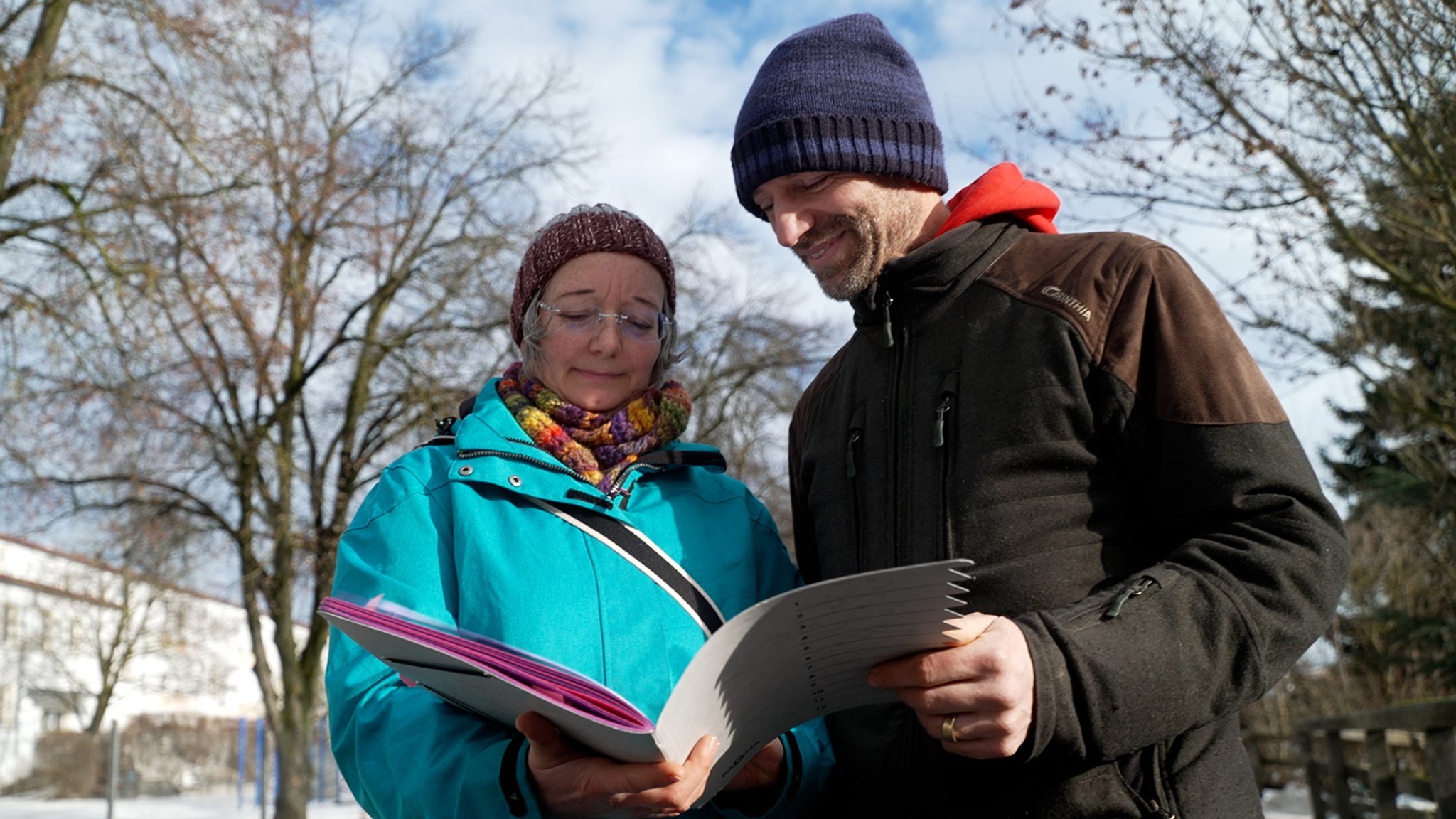 Zwei Menschen schauen in ein Heft voller Dokumente zum Thema Tempo 30. | Bild: Lea Weinberg/BR Zwei Menschen schauen in ein Heft voller Dokumente zum Thema Tempo 30.