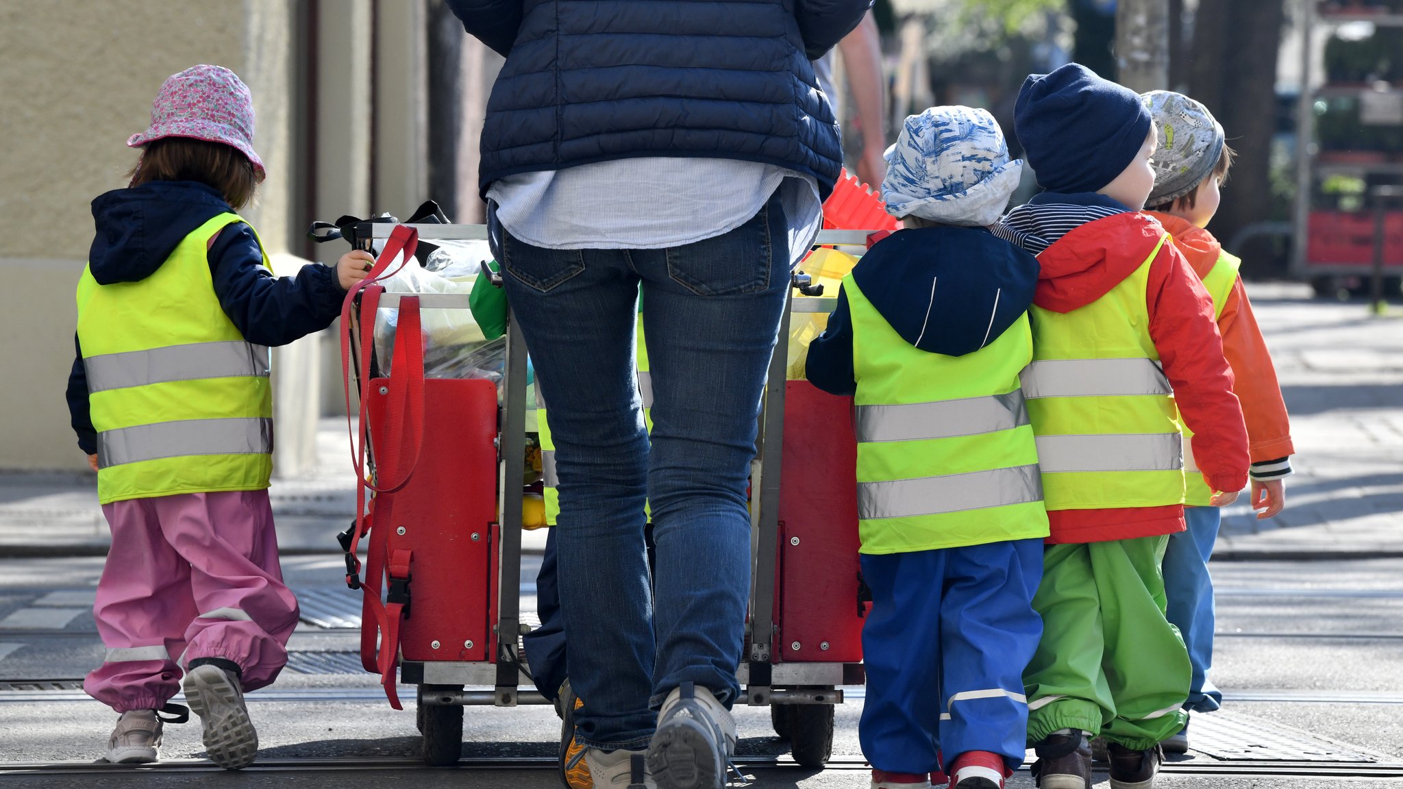 Archivbild: Ein Betreuerin läuft mit mehreren Kindern über einen Bürgersteig | Bild: picture alliance / Peter Kneffel/dpa | Peter Kneffel Archivbild: Ein Betreuerin läuft mit mehreren Kindern über einen Bürgersteig