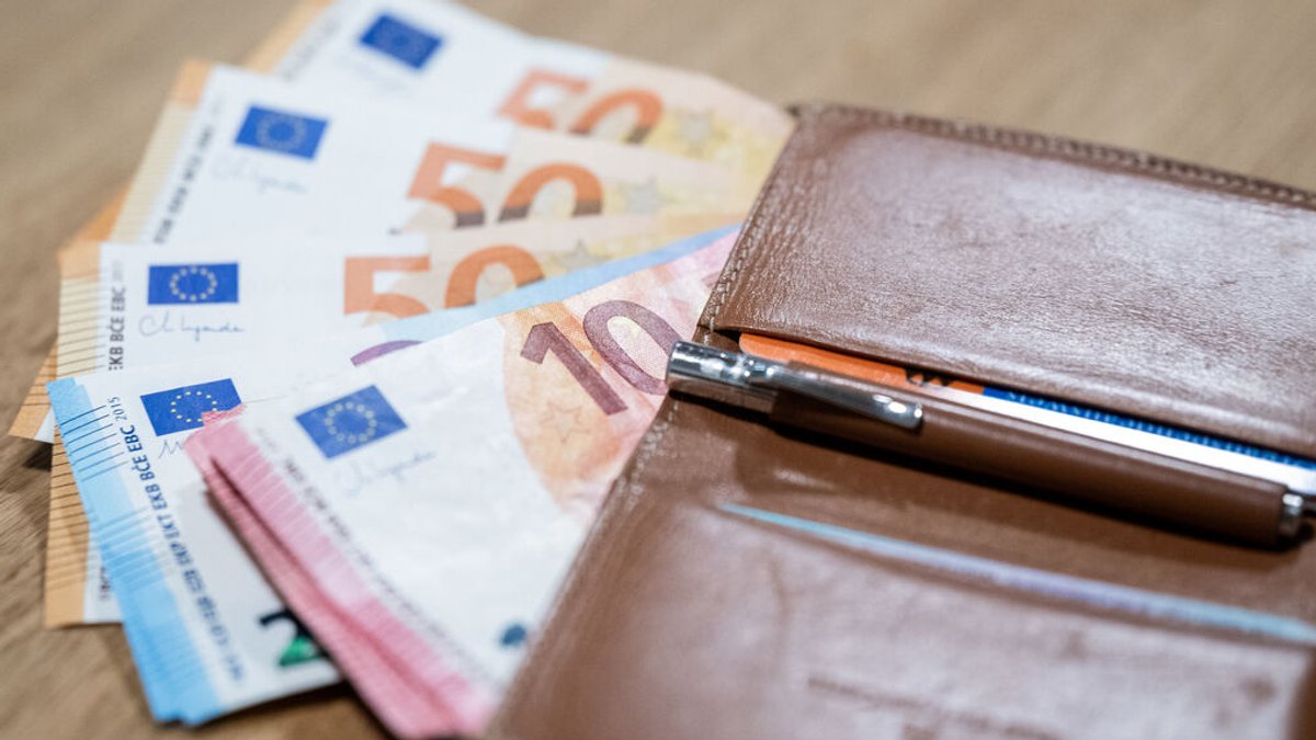 Euro-Banknoten und eine Geldbörse liegen auf einem Tisch.