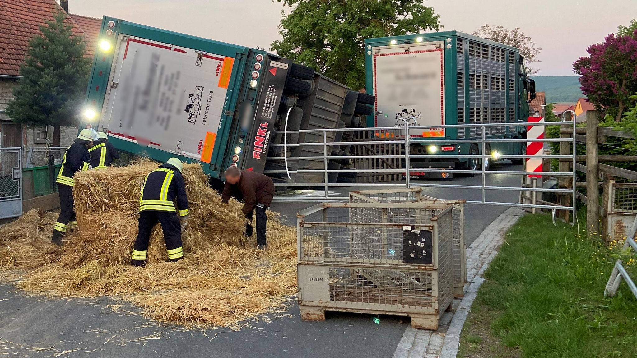 Der umgekippte Schweinetransporter und Helfer der Feuerwehr vor Ort in Iphofen.