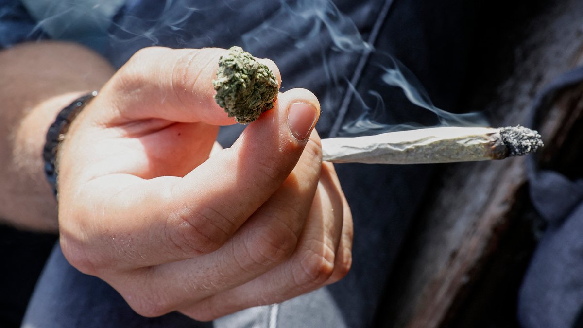 Ein Mensch hält einen Joint in der Hand. Cannabis legalisieren: Ja oder Nein? Seit der Bundestagswahl wird über dieses Thema wieder vermehrt diskutiert.