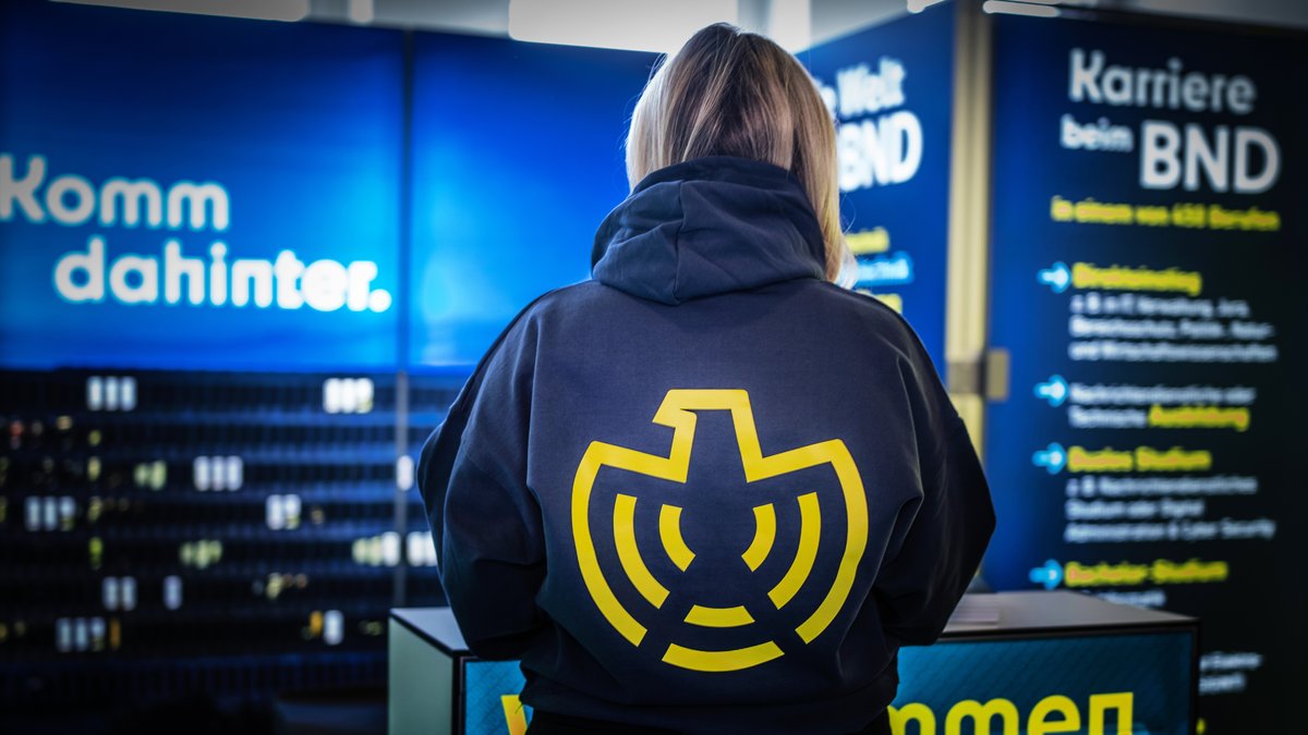 Eine Frau trägt einen Pullover, auf dessen Rücken das neue Logo des Bundesnachrichtendienstes zu sehen ist. 