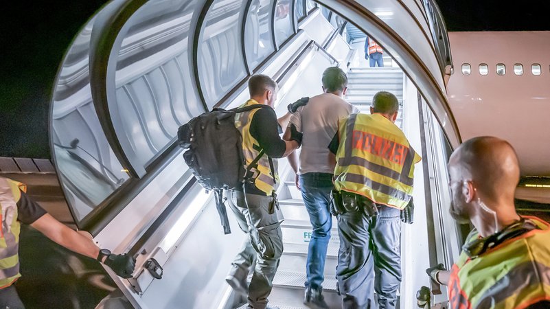 Polizeibeamte begleiten einen Afghanen bei seiner Abschiebung auf dem Flughafen Leipzig-Halle in ein Charterflugzeug (Symbolbild). | Bild: pa/dpa/Michael Kappeler Polizeibeamte begleiten einen Afghanen bei seiner Abschiebung auf dem Flughafen Leipzig-Halle in ein Charterflugzeug (Symbolbild).