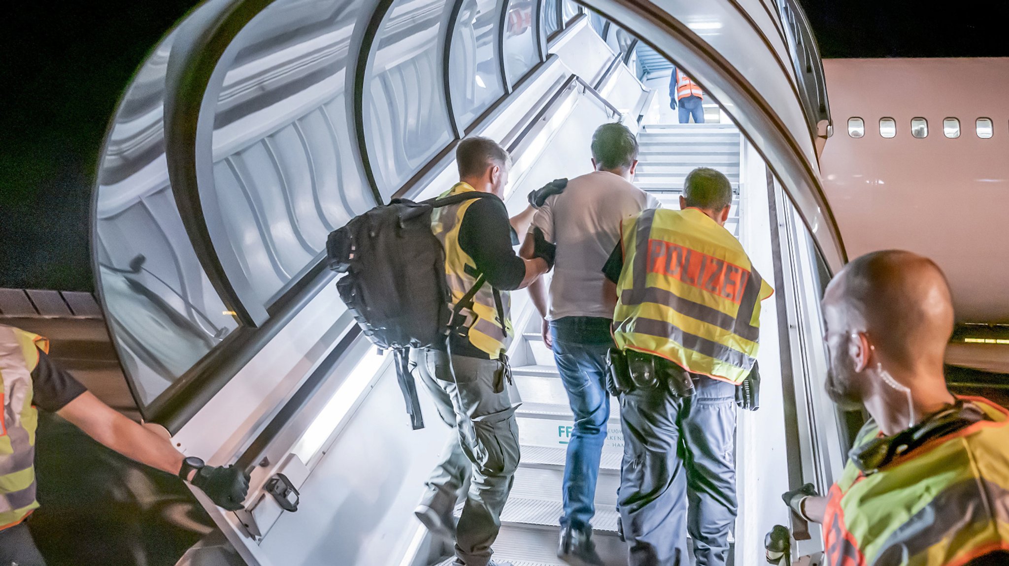 Polizeibeamte begleiten einen Afghanen bei seiner Abschiebung auf dem Flughafen Leipzig-Halle in ein Charterflugzeug (Symbolbild).