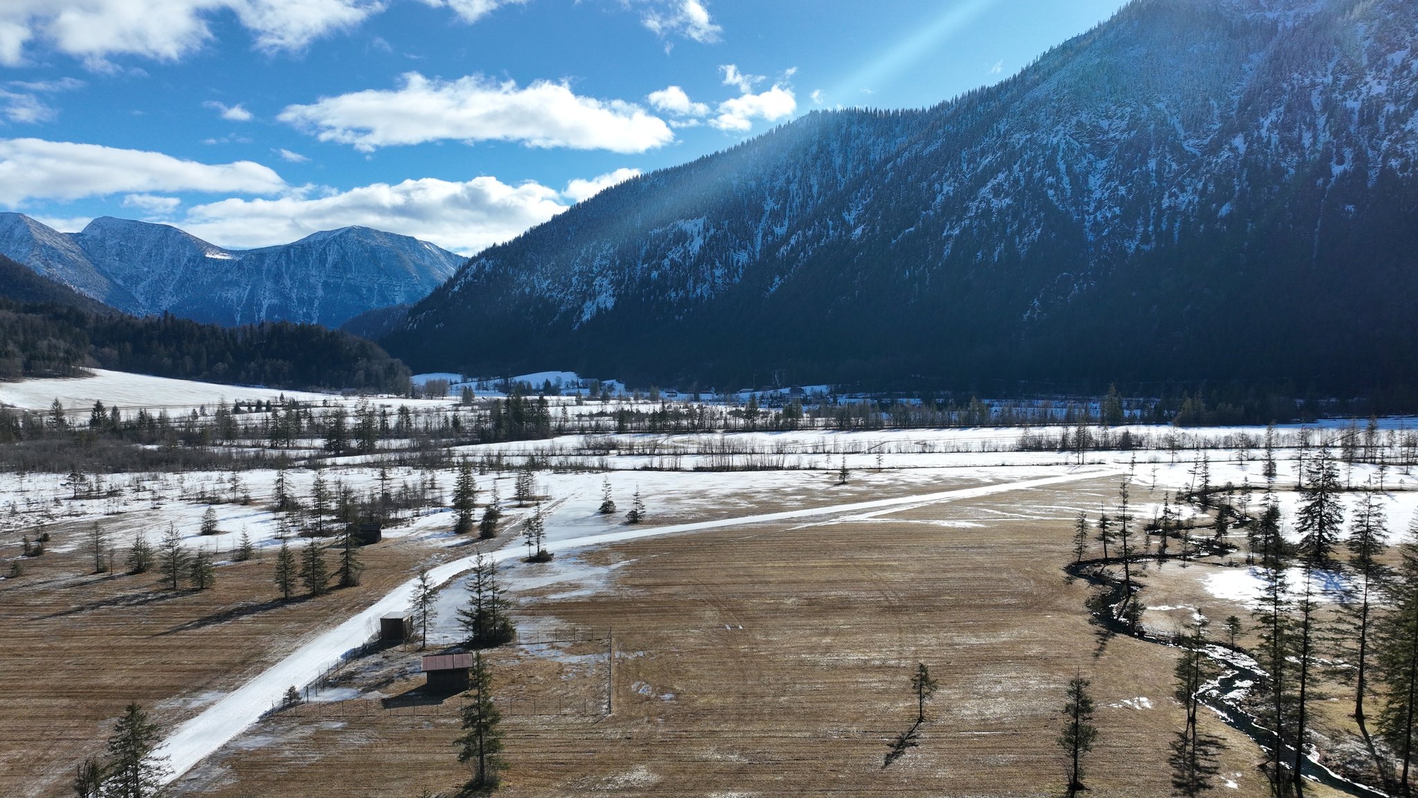 In der Sonne sind nur noch Schneereste auf der Loipe wo eigentlich der König-Ludwig-Lauf stattfinden hätte sollen. 