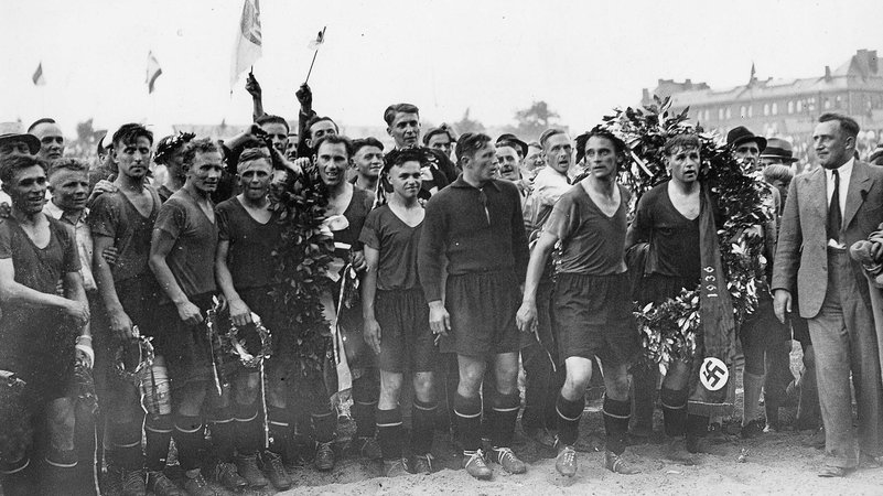 Die Mannschaft des 1. FC Nürnberg feiert die Meisterschaft 1936 - und posiert mit Lorbeerkranz und Hakenkreuz. | Bild: picture alliance / SZ Photo | Scherl Die Mannschaft des 1. FC Nürnberg feiert die Meisterschaft 1936 - und posiert mit Lorbeerkranz und Hakenkreuz.