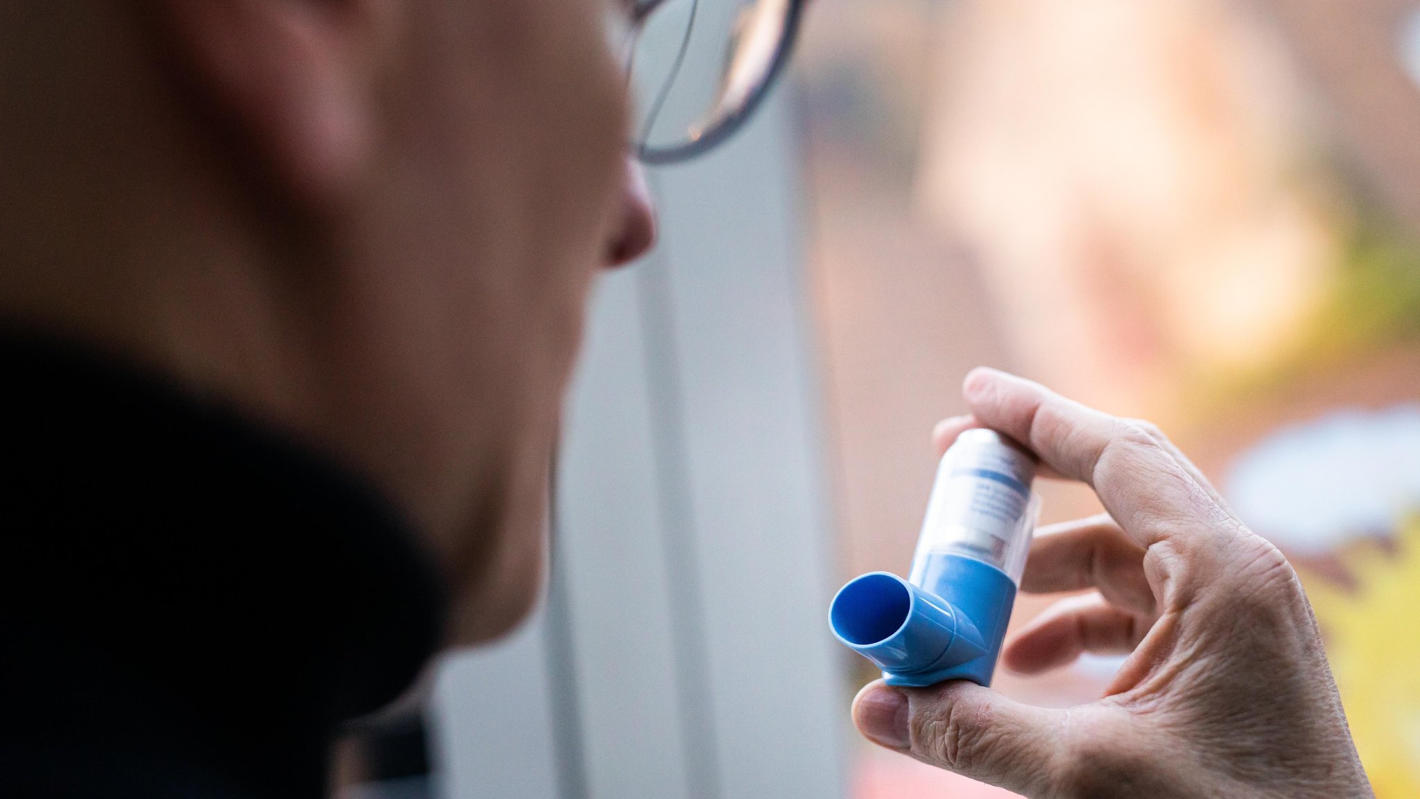 Mann mit Asthma-Spray in der Hand: Asthmasprays könnten ein zentraler Faktor gegen schwere Corona-Krankheitsverläufe sein, so eine neue Studie.