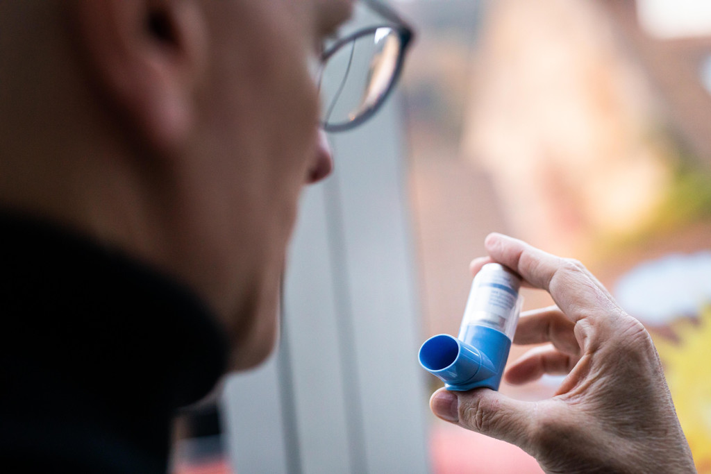 Mann mit Asthma-Spray in der Hand: Asthmasprays könnten ein zentraler Faktor gegen schwere Corona-Krankheitsverläufe sein, so eine neue Studie.