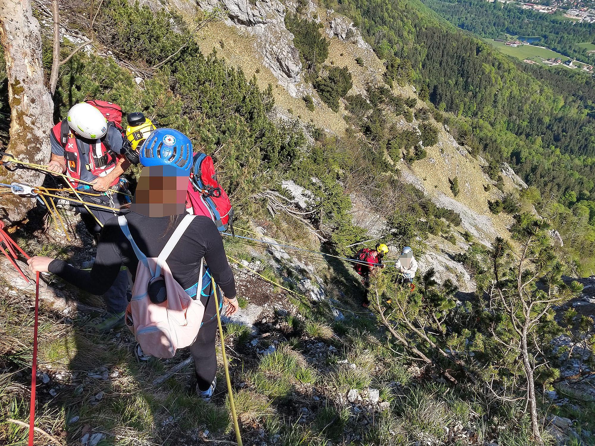 Rettungskräfte mit zwei jungen Frauen am Goldtropfsteig bei der Bergrettung.