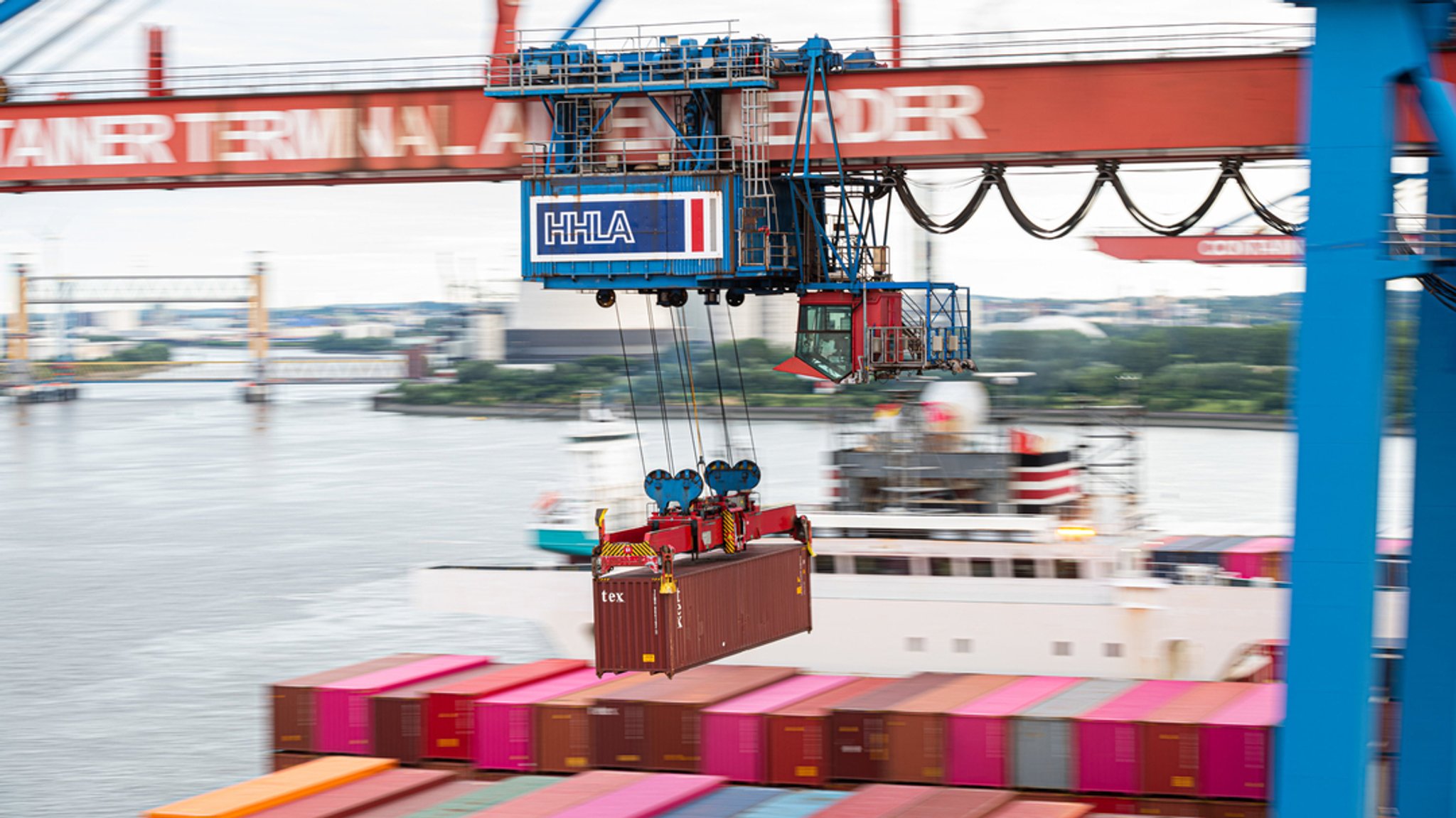 Ein Container wird auf dem Container Terminal Altenwerder im Hamburger Hafen mit einer Containerbrücke auf ein Schiff geladen.