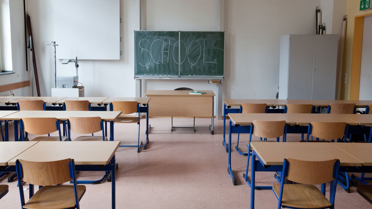 Ein leeres Klassenzimmer mit der Aufschrift "School" auf der Tafel.