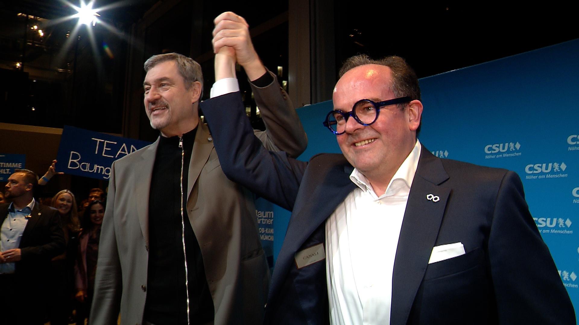 CSU-Chef Markus Söder und der Münchner Oberbürgermeisterkandidat der CSU, Clemens Baumgärnter, recken die Hände in die Luft.