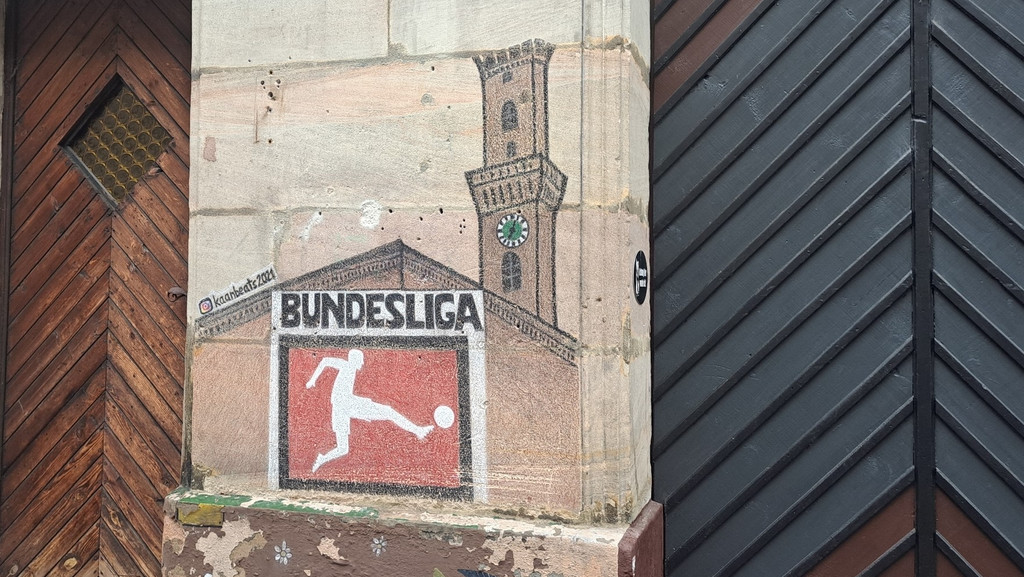Das Fürther Rathaus und ein -"Bundesliga"-Fußballer gemalt an eine Hauswand