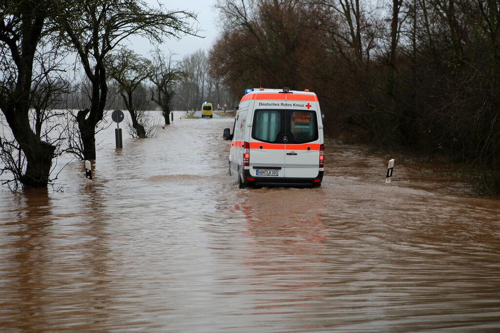 25.12.2023, Thüringen, Windehausen: Ein Krankenwagen fährt über eine von Hochwasser überflutete Straße nach Windehausen. Die Hochwasserlage bleibt in Nordthüringen weiter angespannt. Der Ort Windehausen im Kreis Nordhausen ist vom Wasser eingeschlossen und sollte ab Montagmittag komplett evakuiert werde. Foto: Stefan Rampfel/dpa +++ dpa-Bildfunk +++