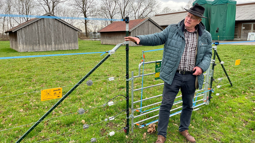 Schafzüchter Christian Mendel zeigt auf der Testfläche die verschiedenen Zaun-Optionen für Tierhalter.