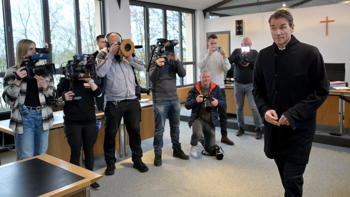 Der angeklagte ehemalige Fußball-Nationaltorwart Jens Lehmann geht zu Prozessbeginn am Freitag an den wartenden Journalisten vorbei.