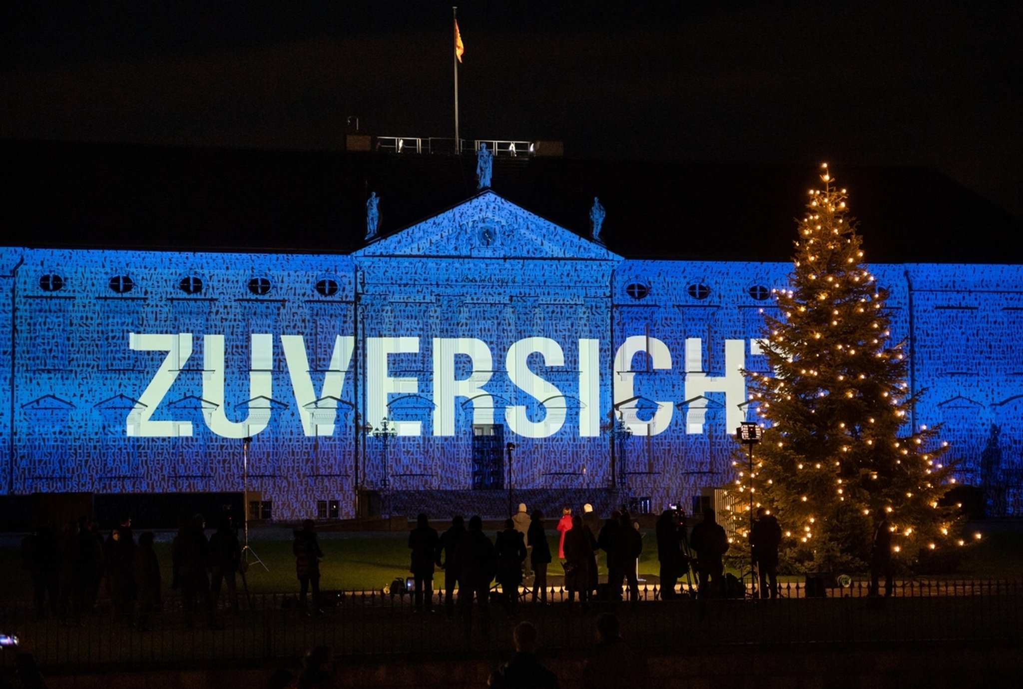 dpatopbilder - 15.12.2020, Berlin: Bundespräsident Frank-Walter Steinmeier und seine Frau Elke Büdenbender schauen sich an, wie zahlreiche Bilder und Botschaften zum Start des Projekts "Lichtblick" auf die Fassade von Schloss Bellevue projiziert werden. Vom 15. bis 17.12.2020 wird die Fassade von Schloss Bellevue mit einer künstlerischen Lichtprojektion angestrahlt, bei der Botschaften gezeigt werden, die Menschen aus ganz Deutschland eingeschickt haben. Mit dem "Lichtblick" möchte Bundespräsident Steinmeier am Ende dieses besonderen, durch die Corona-Pandemie geprägten Jahres ein Zeichen der Ermutigung und des Zusammenhalts setzen. Foto: Bernd von Jutrczenka/dpa +++ dpa-Bildfunk +++