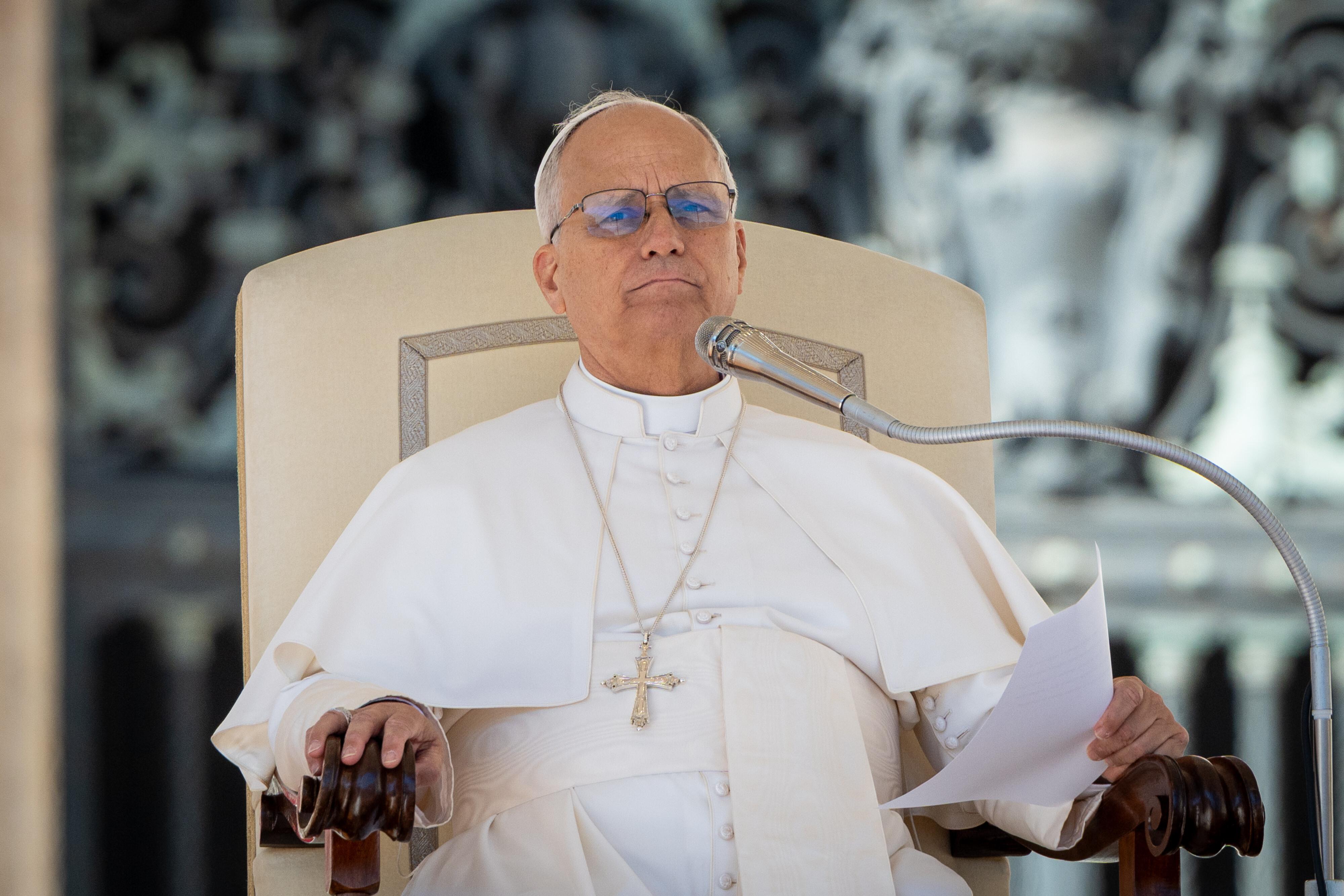 Papst Leo XIV. sitz auf einem Stuhl und hat einen Zettel in der Hand.