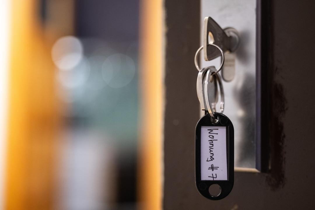 Ein Schlüssel mit der Aufschrift «Wohnung #7» hängt an einer Wohnungseingangstür.