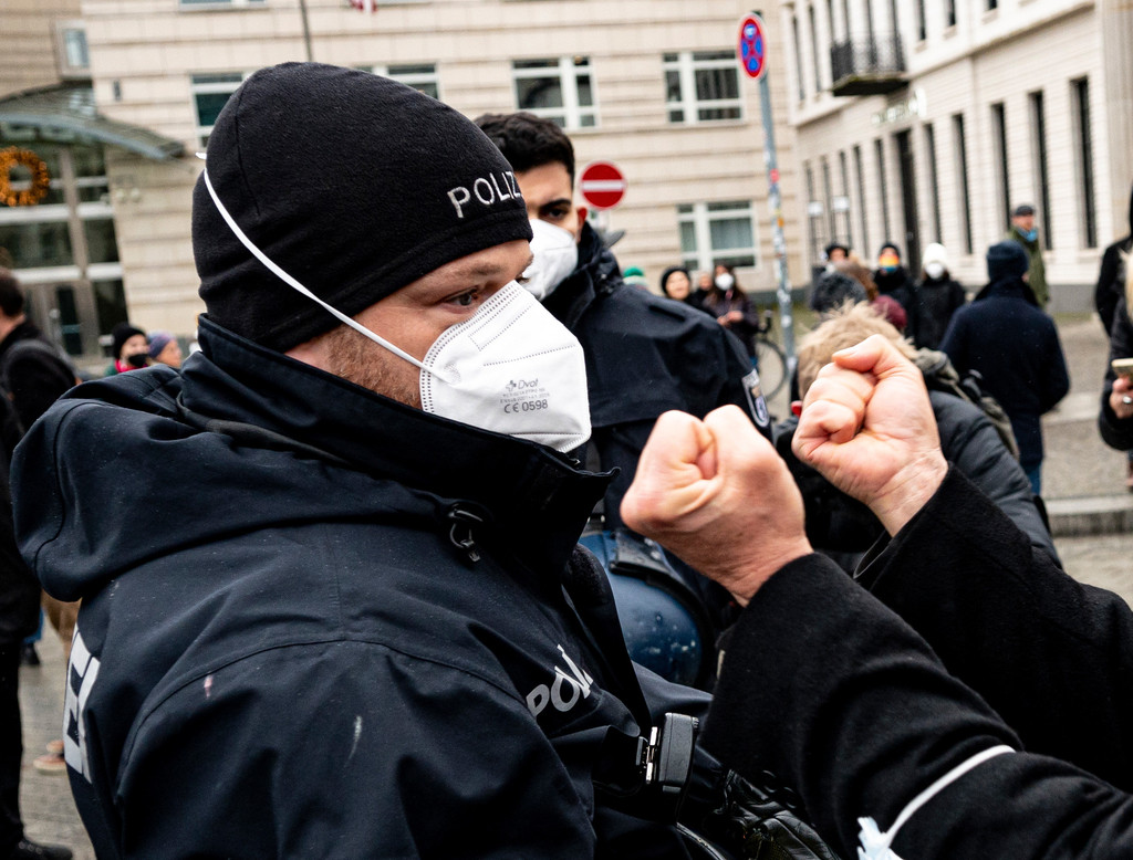 Ein Teilnehmer einer verbotenen Demonstration von Gegnern der Corona-Regeln streckt im Dezember 2021 seine Fäuste einem Polizisten entgegen. 