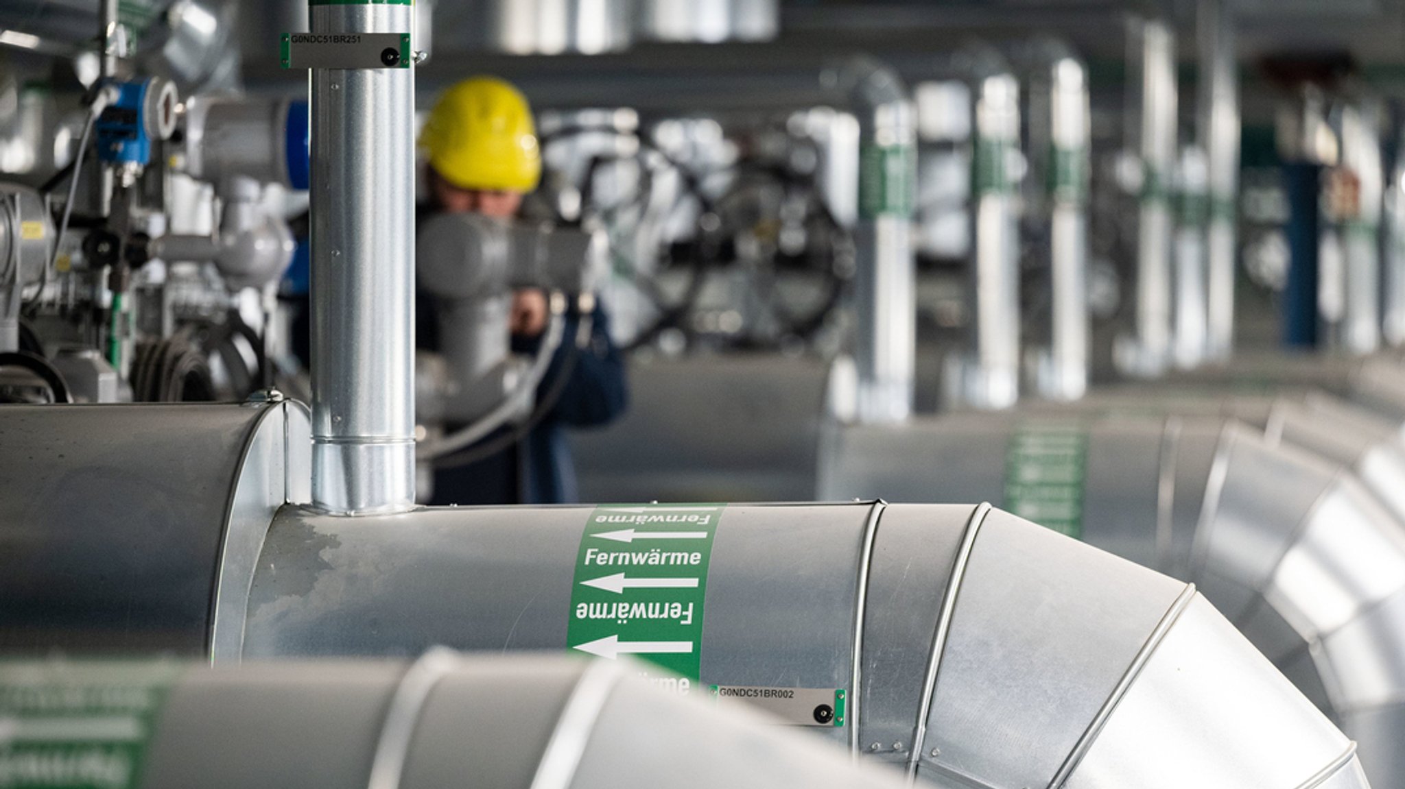 Ein Mitarbeiter kontrolliert die Fernwärme-Verteilstation in einem Heizkraftwerk.