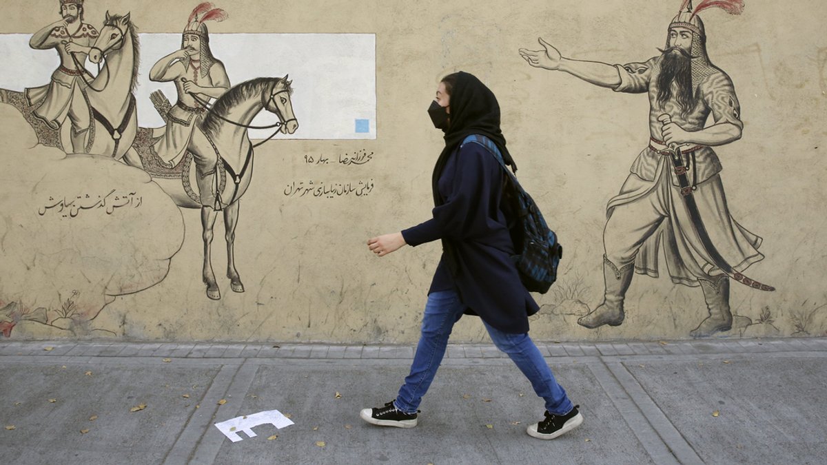 Symbolbild: Ein iranisches Mädchen geht an einer Häuserfassade entlang. 