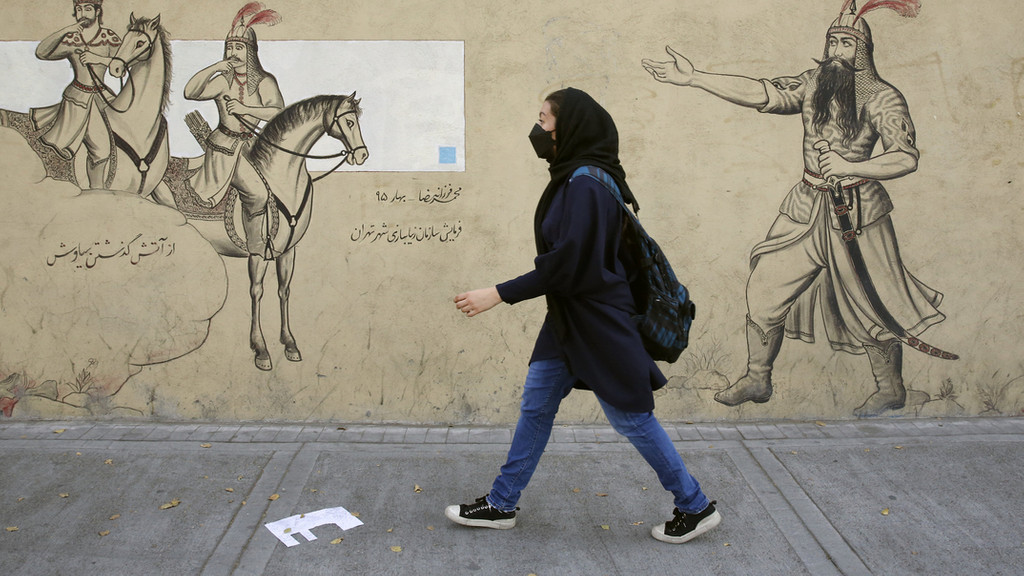 Symbolbild: Ein iranisches Mädchen geht an einer Häuserfassade entlang. 