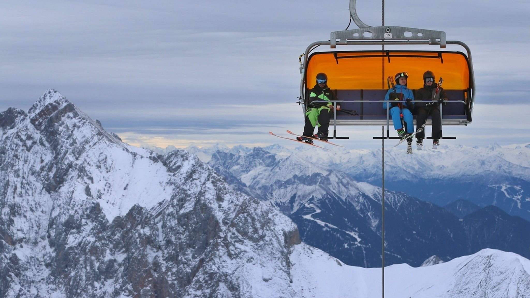 ARCHIV - 30.11.2018, Bayern, Grainau: Wintersportler sitzen auf der Zugspitze in einem Sessellift. (zu dpa «Skistart an der Zugspitze - Zuversicht in schwierigen Zeiten») Foto: Karl-Josef Hildenbrand/dpa +++ dpa-Bildfunk +++