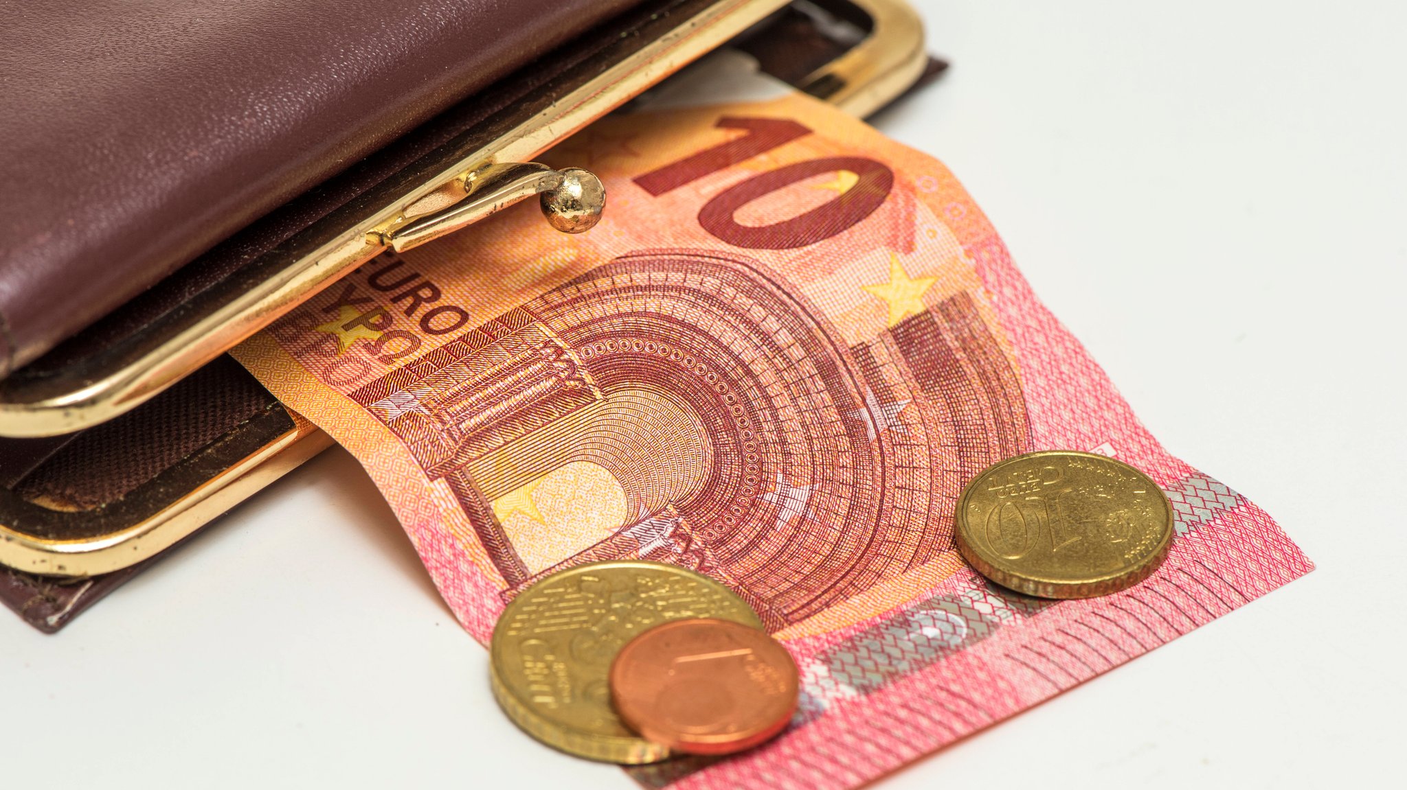 Aus einer Geldbörse fallen Münzen und ein Geldschein heraus. | Bild: picture alliance / SZ Photo | Wolfgang Filser Aus einer Geldbörse fallen Münzen und ein Geldschein heraus.