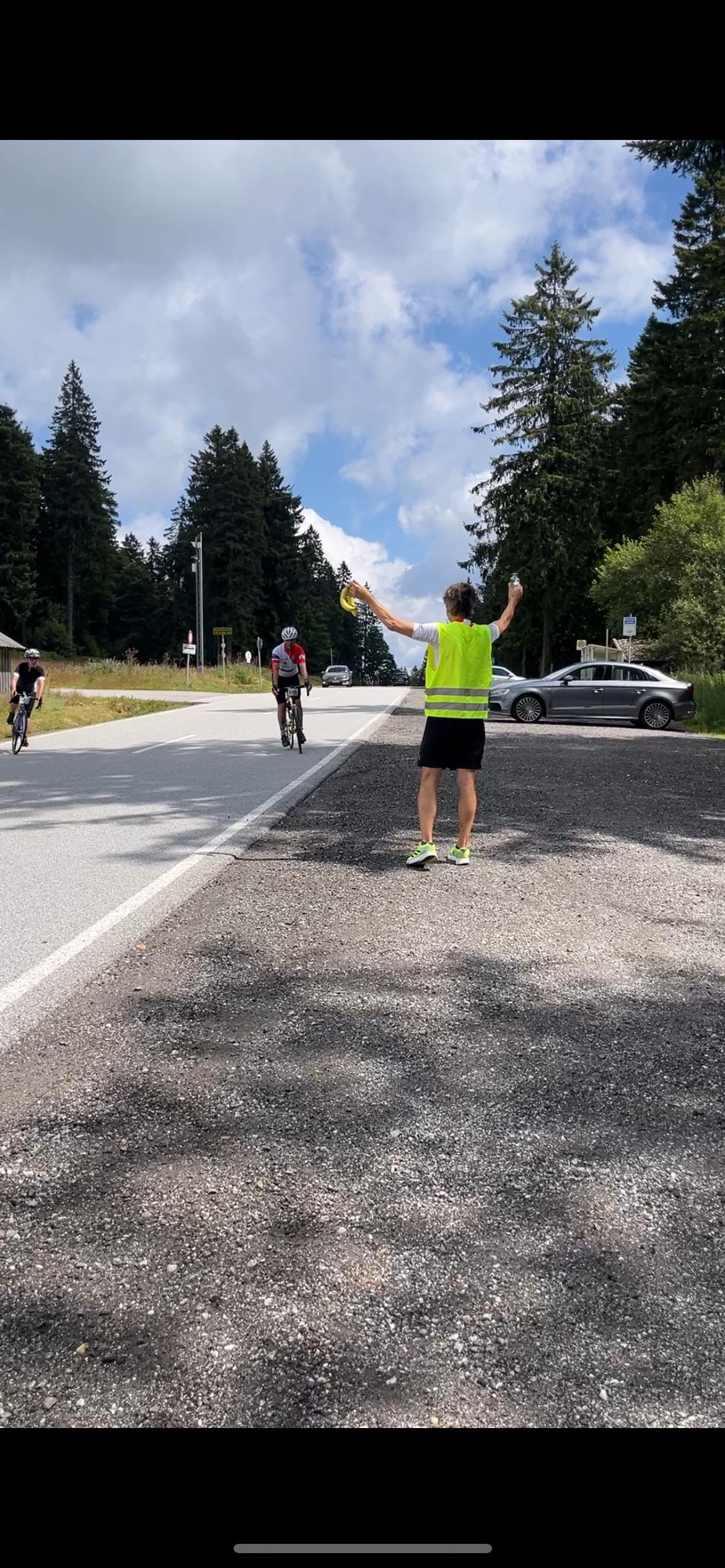Ein Mann versorgt Radsportler mit Bananen