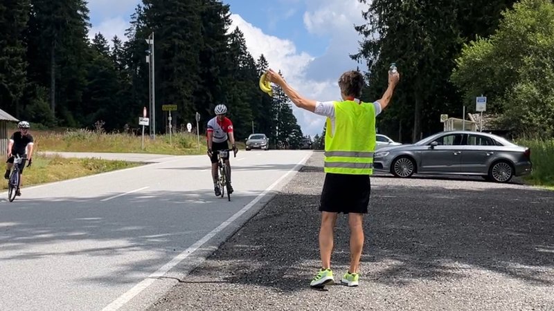 Ein Mann versorgt Radsportler mit Bananen | Bild: BR/Meike Föckersperger Ein Mann versorgt Radsportler mit Bananen