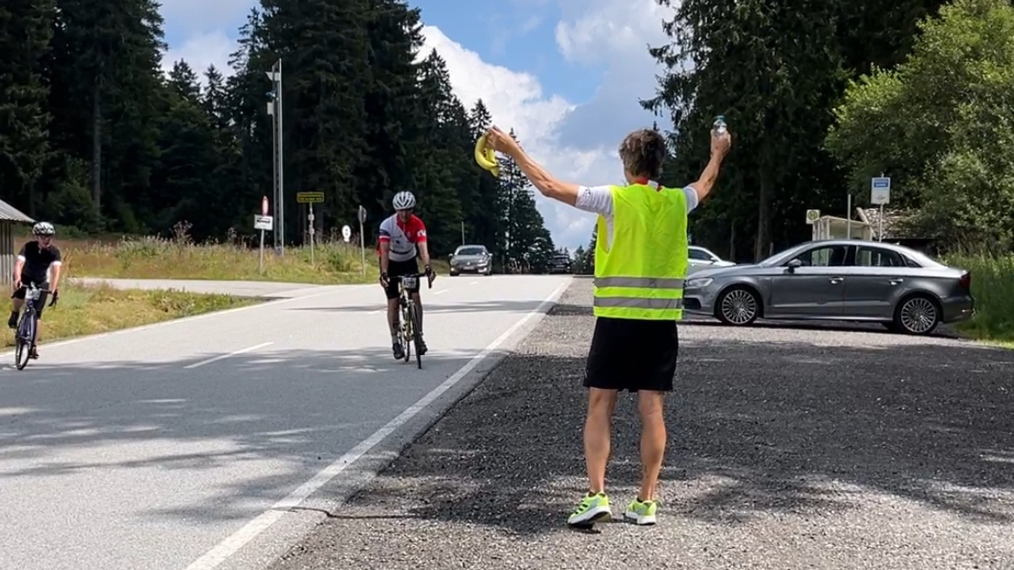 Ein Mann versorgt Radsportler mit Bananen