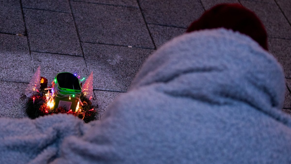 Obdachloser in Wolldecke vor beleuchteter Elektro-Krippe (Symbolbild)